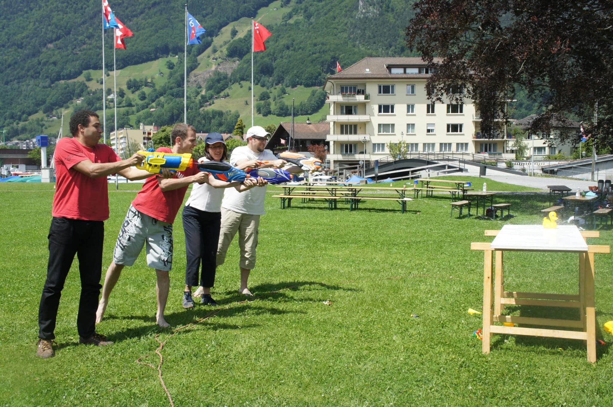 People playing with water pistols outdoors.