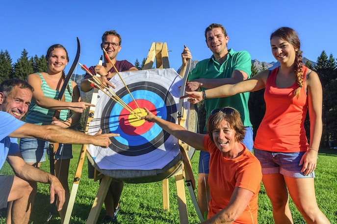 Group archery outdoors, target hit.