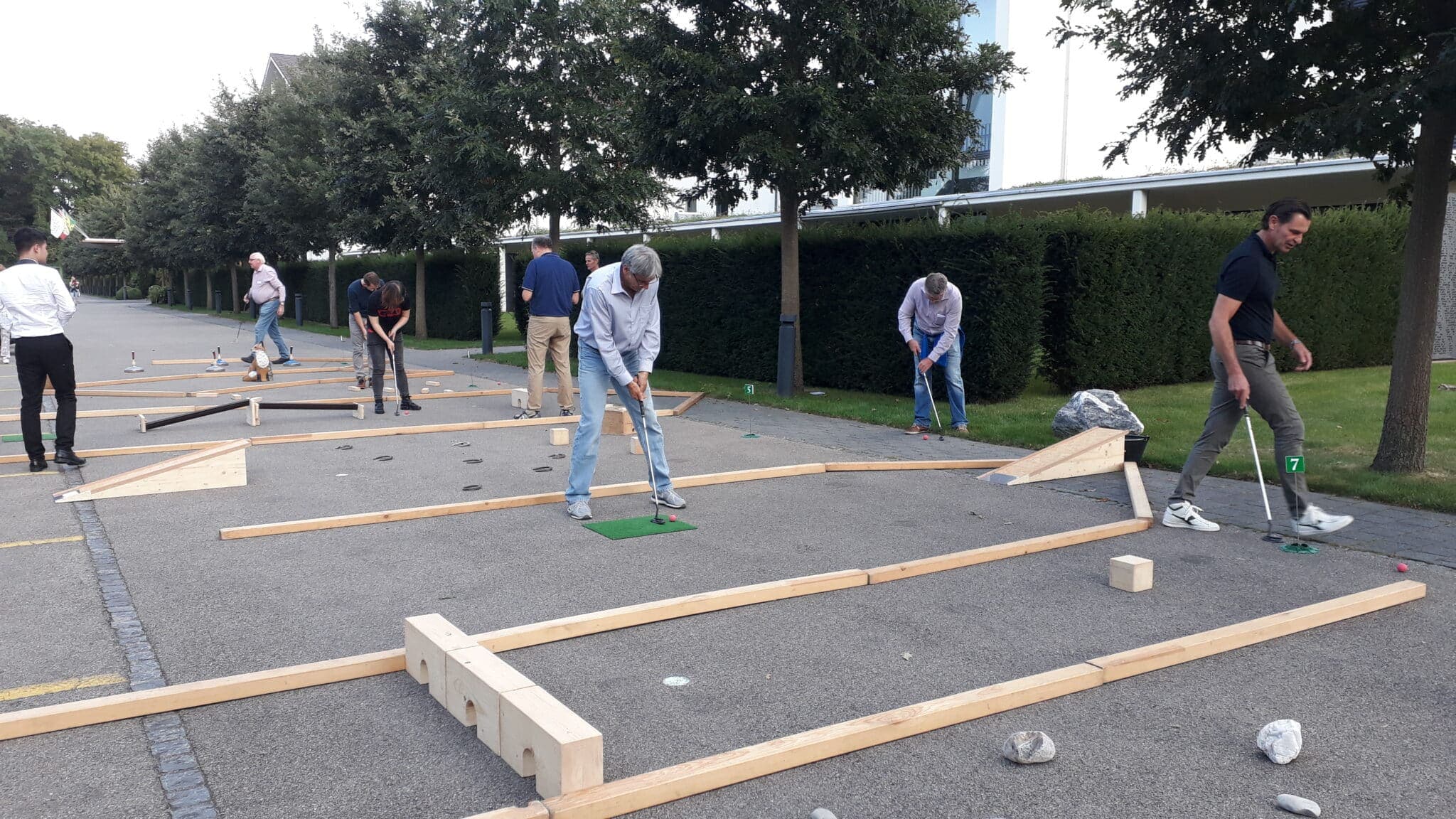 Menschen spielen Minigolf im Freien.